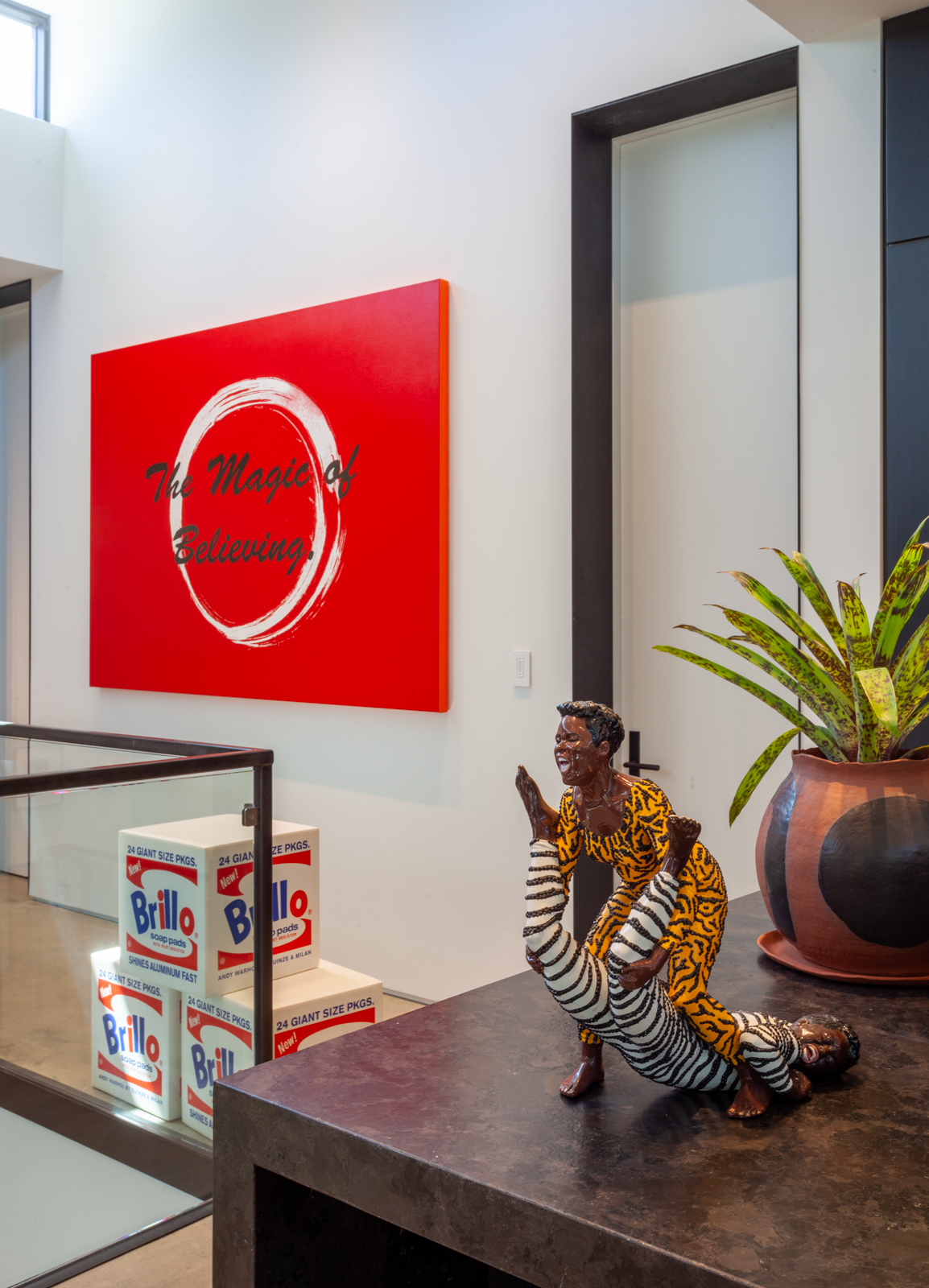 Mickalene Thomas, Brawlin’ Spitfire Wrestlers, 2008 (sculpture), and The Magic of Believing, 2014 (painting), in the Gupta Moss collection, Chicago.